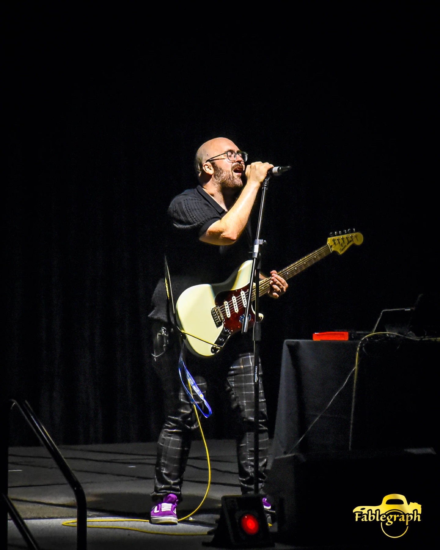 Musician performing on stage at Queen City Anime Con
